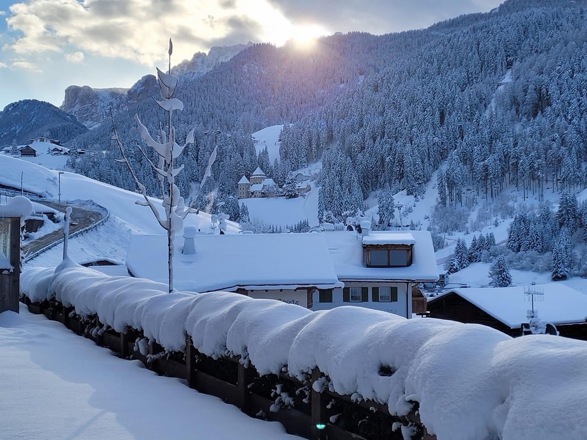 Santa Cristina in Val Gardena sotto la neve fresca, con Castel Gardena tra gli alberi